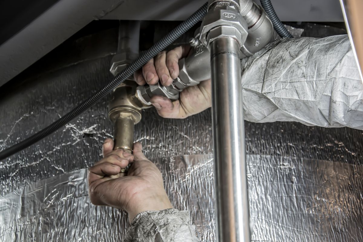 Towne Plumbing repairing pipe fittings on a job in the Traverse City area